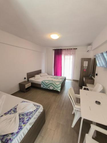a room with two beds and a table and chairs at VILLA SEVI in Nea Vrasna