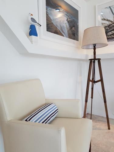 a living room with a white couch and a lamp at Hotel Faro de San Vicente in San Vicente de la Barquera