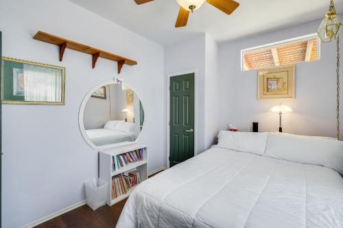 a bedroom with a white bed and a mirror at Navigate Stays Pioneertown Retreat w Hot Tub in Pioneertown