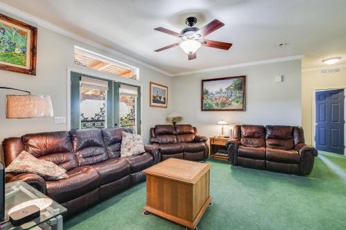 a living room with leather furniture and a ceiling fan at Navigate Stays Pioneertown Retreat w Hot Tub in Pioneertown