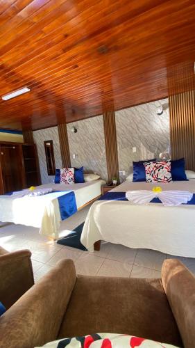 a bedroom with three beds and a wooden ceiling at Nafre House B&B Monteverde in Monteverde Costa Rica