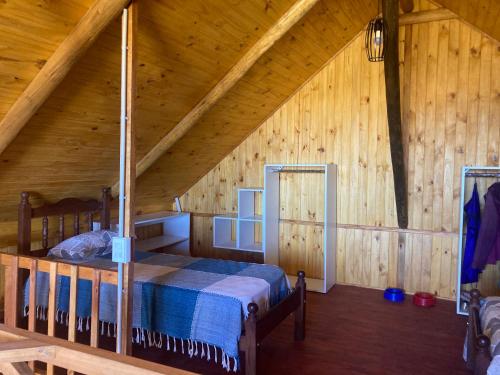 a bedroom with a bed in a wooden cabin at Luna y Mar in Mar del Sur