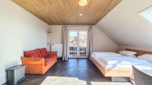 a attic bedroom with a bed and a couch at Gästehaus Hornstein in Nonnenhorn