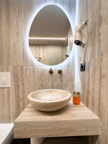 a bathroom with a stone sink and a mirror at Preveza Central Stay in Preveza