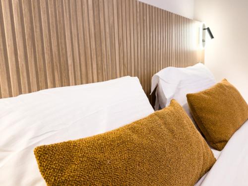 a bed with white sheets and brown pillows at Preveza Central Stay in Preveza