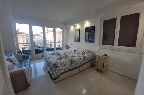 une chambre avec un lit, une chaise et des fenêtres dans l'établissement Center Cannes Hippocampe, à Cannes