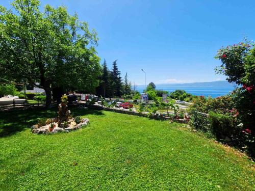 a park with a green lawn with trees and flowers at Apartment Novakoski in Lagadin