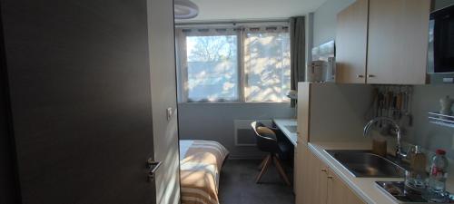 ヴァンドゥーヴル・レ・ナンシーにあるStudio rénové Nancy Brabois, proche CHRU campusの小さなキッチン(ベッド1台付)、窓が備わります。