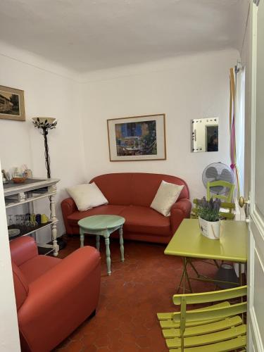 un salon avec un canapé rouge et une table dans l'établissement LA Maison BARNOIN GITE, à Bouyon