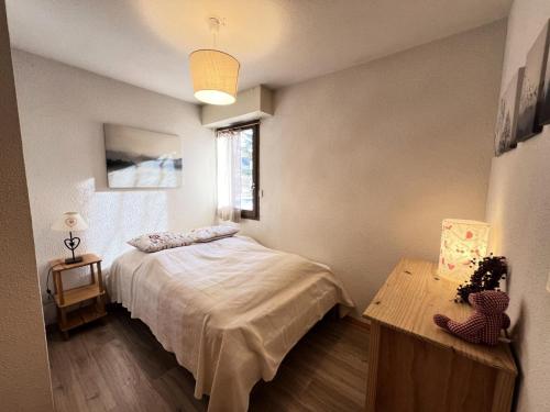 une chambre avec un lit, une table et une fenêtre dans l'établissement Résidence Jardin Alpin Anemone - Appartement spacieux · Accès pistes par navette · Vue montagne MAE-0141, à La Salle Les Alpes