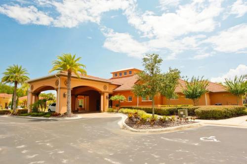 a large orange building with palm trees in front of it at Ground Floor Gathering up to 9 guests BL387 in Kissimmee