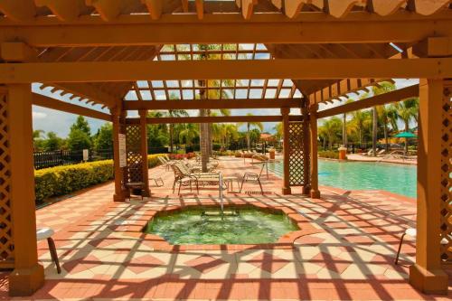 a pavilion with a table and chairs and a pool at Ground Floor Gathering up to 9 guests BL387 in Kissimmee