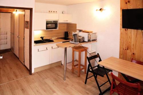 une petite cuisine avec une table et une salle à manger dans l'établissement Résidence Le Pouzenc - Studio calme pieds de pistes MAE-0344, aux Orres