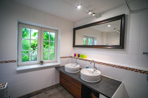 a bathroom with two sinks and a mirror at Haus am Leuchtturm in Pellworm