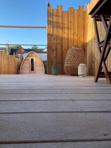 a wooden deck with a wooden fence and a building at Les Secrets de la Baie - La Jimbaran - Suite d'exception Spa & Sauna in Étaples