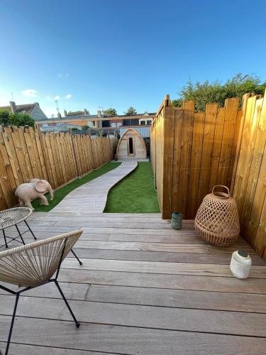 a wooden patio with a wooden fence and a wooden walkway at Les Secrets de la Baie - La Jimbaran - Suite d'exception Spa & Sauna in Étaples