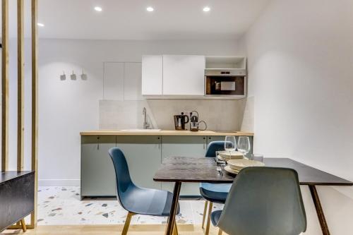une cuisine avec une table et des chaises dans une pièce dans l'établissement La Nuit Etoilée - Moderne & Elégant - Marais, à Paris