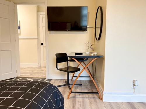 a room with a table and a chair and a television at 2-A Diamond in Yonkers in Yonkers