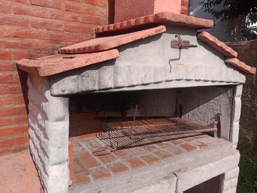 an outdoor pizza oven with a brick wall at Alquiler Casa Chacabuco 2 in Chacabuco