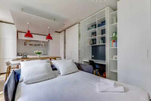 une chambre avec un grand lit blanc avec deux oreillers dans l'établissement La Douce Nuit - Moderne - Elégant - Rénové, à Paris