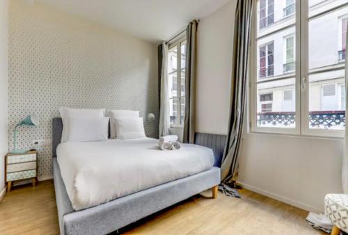 une chambre avec un lit et une grande fenêtre dans l'établissement La Douce Nuit - Moderne - Elégant - Rénové, à Paris