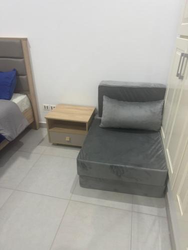 a small room with a bed and a night stand at Studio Résidence Prestige in Mahdia