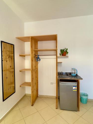 a room with a kitchen with a refrigerator and shelves at Ocean Life Dahab in Dahab