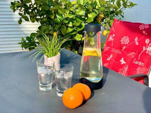 a table with oranges and a bottle of wine and glasses at Ferienhaus Jäger in Friedrichshafen