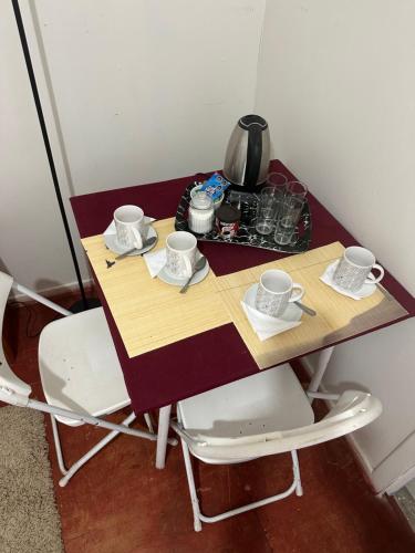 un tavolo con tazze e piattini sopra di Hostal Duchantu a Dichato