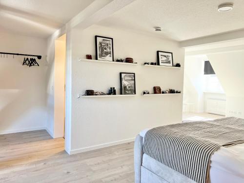 a bedroom with a bed and shelves on the wall at Neu MAKERS and ROOMS APARTMENTS Rosental am Schlosspark Detmold in Detmold
