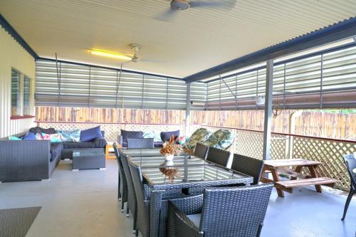 a room with a table and chairs and a couch at The Hopeful Hut-Cosy beach vibes-Bring the dog & boat in Kurrimine Beach