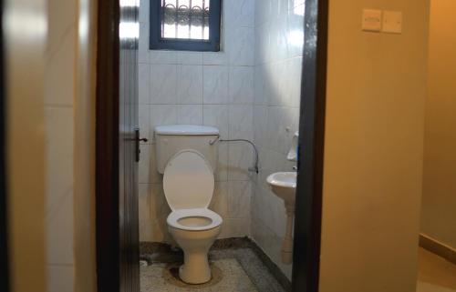 a bathroom with a toilet and a sink at ViRRA Suites in Mbarara