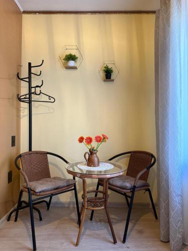a table with two chairs and a vase with flowers on it at Holiday house Neilandi in Engure
