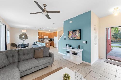 a living room with a gray couch and a blue wall at 4BR Townhome with Lake View – BL481 in Kissimmee