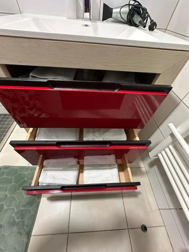 a bathroom with a sink and a red drawer at Une appartement entier à Brive la gaillarde in Brive-la-Gaillarde