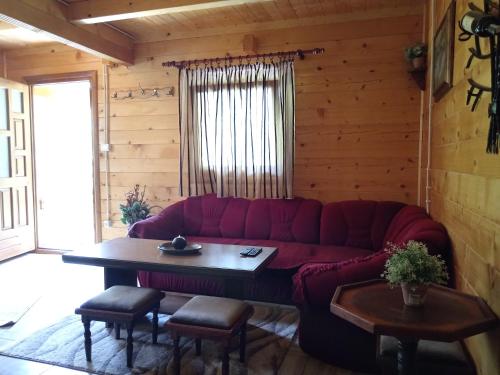 a living room with a red couch and a table at Apartmani Kajkut in Banja Luka