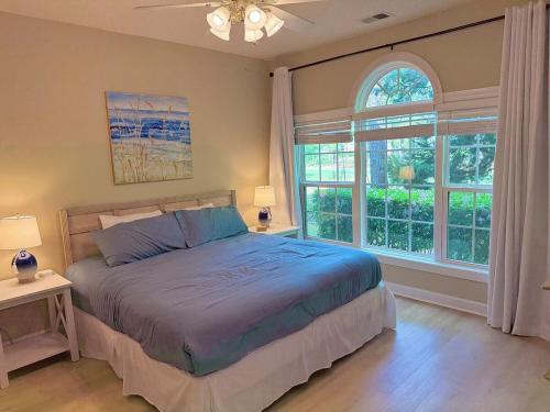 a bedroom with a bed and a large window at Stay Salty-Newly Renovated-Barefoot Resort, 2 Pools, 2 miles to beach in North Myrtle Beach