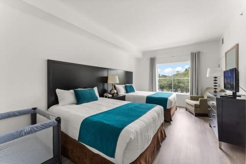 a hotel room with two beds and a television at 1BR FREE Shuttle to Disney Parks HS305 in Orlando