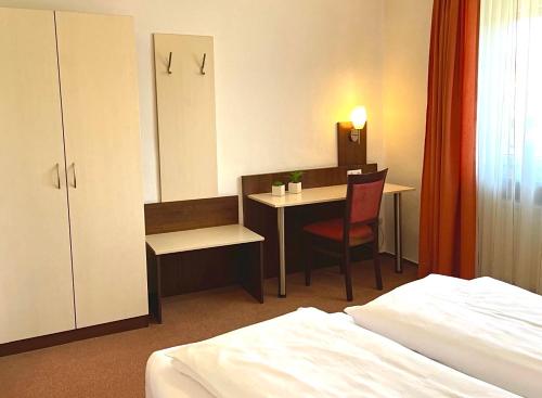 a hotel room with a bed and a desk and a table at Ferienhaus Jäger in Friedrichshafen