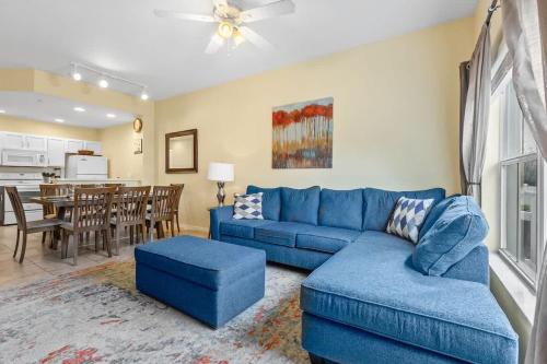 a living room with a blue couch and a kitchen at Relaxing 3BR Haven for 8 at Seven Dwarfs SD2610 in Kissimmee