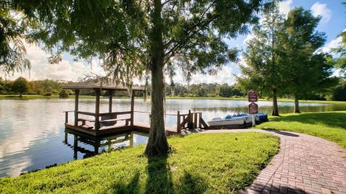 a dock and a boat on a lake at Relaxing 3BR Haven for 8 at Seven Dwarfs SD2610 in Kissimmee