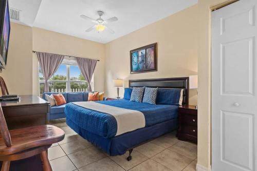 a bedroom with a blue bed and a couch at Relaxing 3BR Haven for 8 at Seven Dwarfs SD2610 in Kissimmee