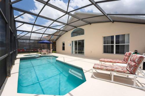 a swimming pool with a glass ceiling and two chairs at 4 BR No carpet Just Remodeled Unit SR1205 in Kissimmee