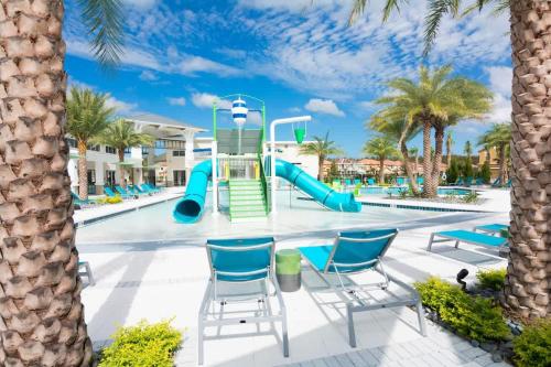 a pool with a slide at a resort with palm trees at Ground floor spacious house 4BR VP2512 in Kissimmee