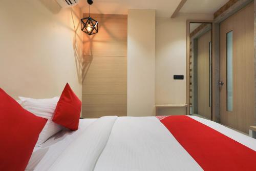 a bedroom with a bed with red and white pillows at Collection O Hotel Harriot in Somarda Kauasot