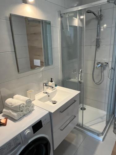 a bathroom with a washing machine and a washer at MC Apartamenty Ściegiennego 3 in Augustów