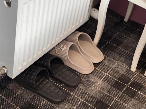 a pair of sandals are sitting under a crib at Bumble’s Barn in Slamannan