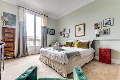 une chambre avec un grand lit et une grande fenêtre dans l'établissement L'Ecrin - Lumineux et Vues splendides -Batignolles, à Paris