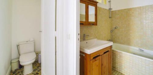 une salle de bain avec un lavabo, des toilettes et une baignoire dans l'établissement Le Breteuil Calme & Lumineux Invalides, à Paris