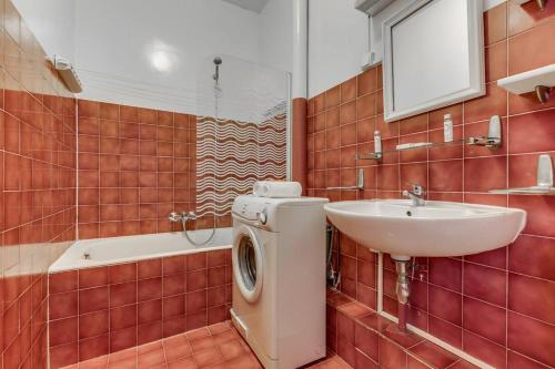 une salle de bain avec une machine à laver et un lavabo dans l'établissement Le Rubis de Paris élégant Notre-Dame & Panthéon, à Paris